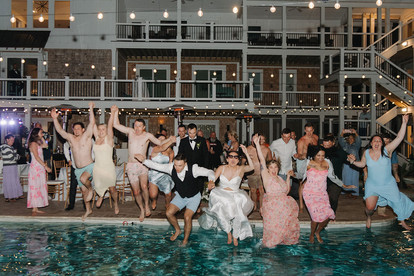 Wedding guests joining the couple for a pool jump after the reception