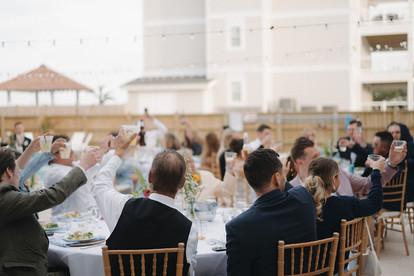 Guests raising their glasses to toasts at Outer Banks wedding