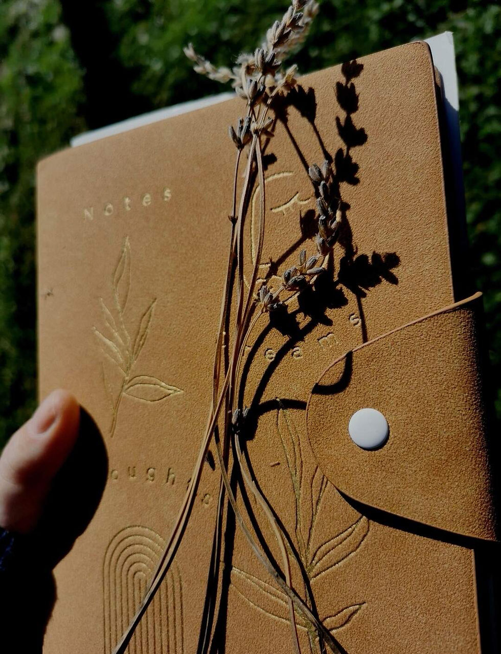 A brown notebook and lavander flowers.