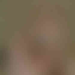 Women hand holding pebbles, sea glass and one seashell.