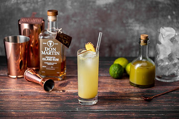 Dark and Stormy cocktail made with Don Martin Rum and ginger beer, served over ice with a lime wedge garnish.