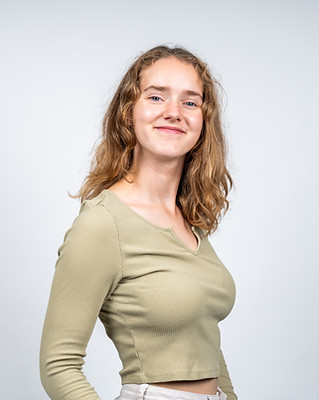 Vrolijke portretfoto van eigenaar en oprichter Dione Maarsen in een groen shirt