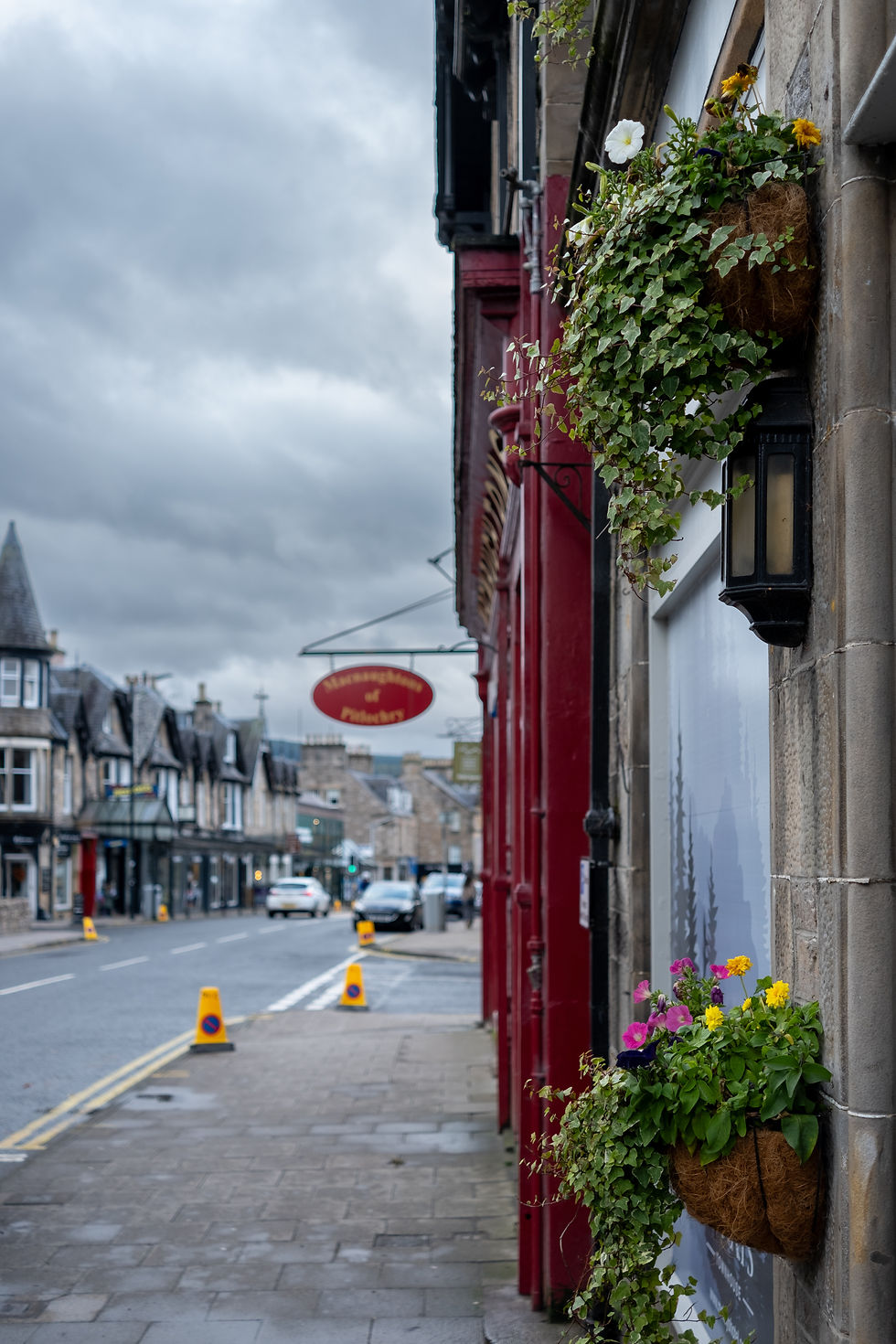 The Streets of Pitlochry with shops and cars