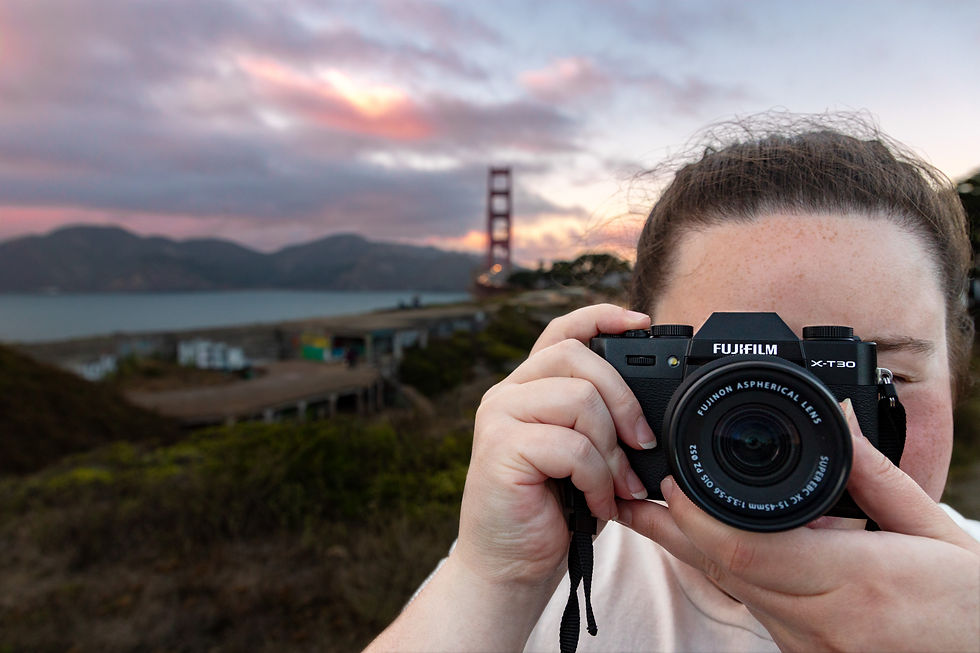 Girl Holding a FujiFilm Camera in front of the Golden Gate bridge