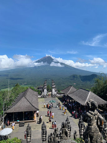 Blick über den Lempuyang Tempel auf Bali mit dem Vulkan Agung im Hintergrund und traditionellen Tempelbauten.