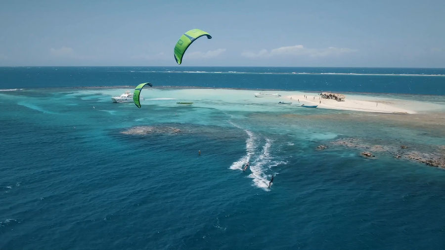 Aerial view of Cayo Arena's white sandbank with kites