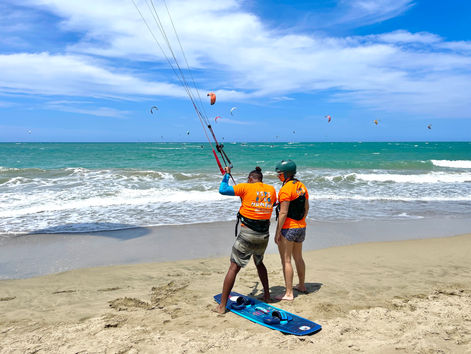 Kite Buen Hombre instructor teaching a student on the beach in Cabarete, kites flying overhead