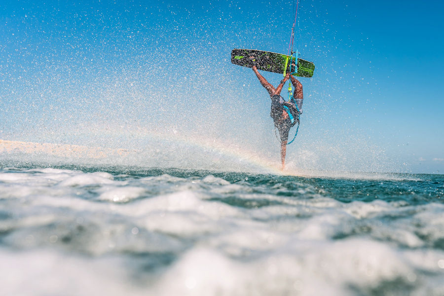 Kitesurfer performing a handplant jump at Playa Popa