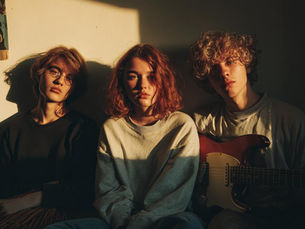 Création d'un moodboard Trois jeunes gens sont assis sur un lit.