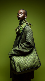 Portrait éditorial haute couture d’une femme noire stylisée dans des tons olive monochromes sur un f