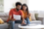 Happy couple reviewing tax documents symbolising relief provided by personalised tax solutions from Elite Tax Compliance