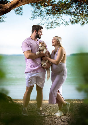 Mies ja nainen yhdessä koiransa kanssa meren rannalla