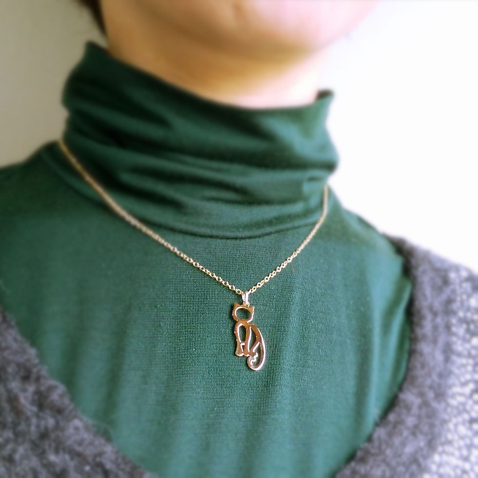 サムネイル： A model is wearing gold cat necklace on green top.