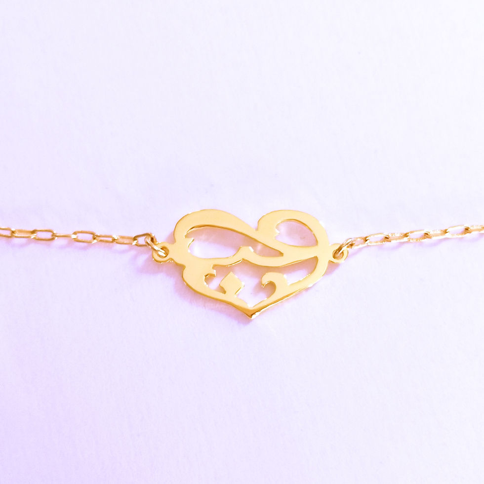 サムネイル： Gold heart shape bracelet designed with Arabic word on white.