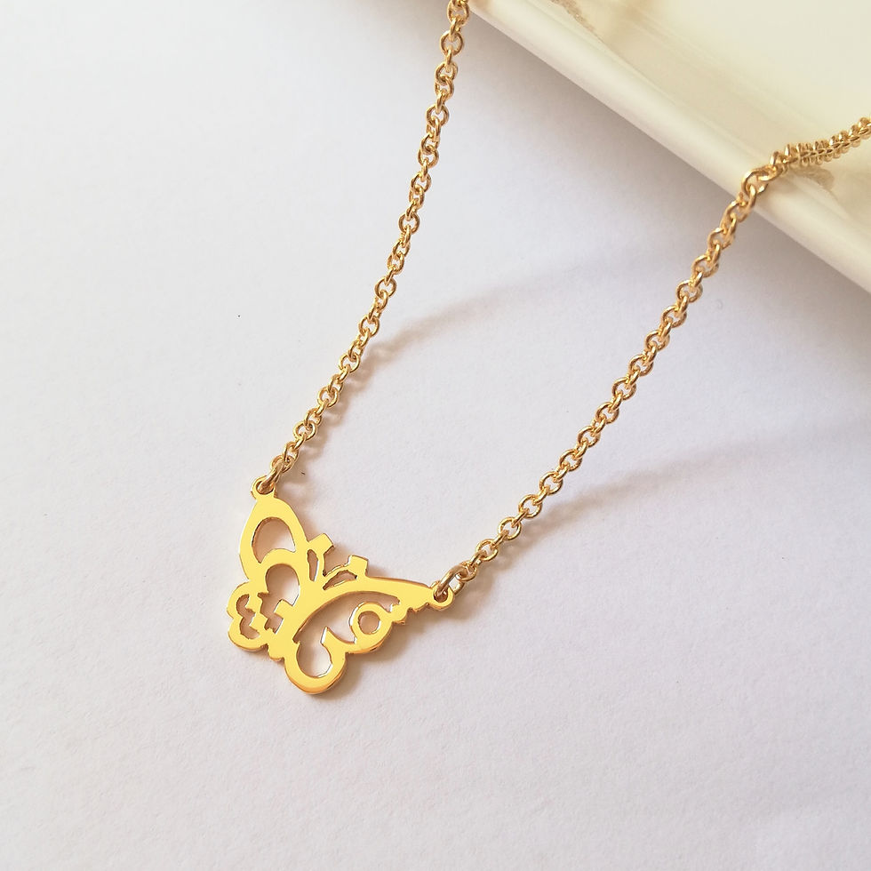 サムネイル： Gold small butterfly necklace designed with Arabic lying on white board.