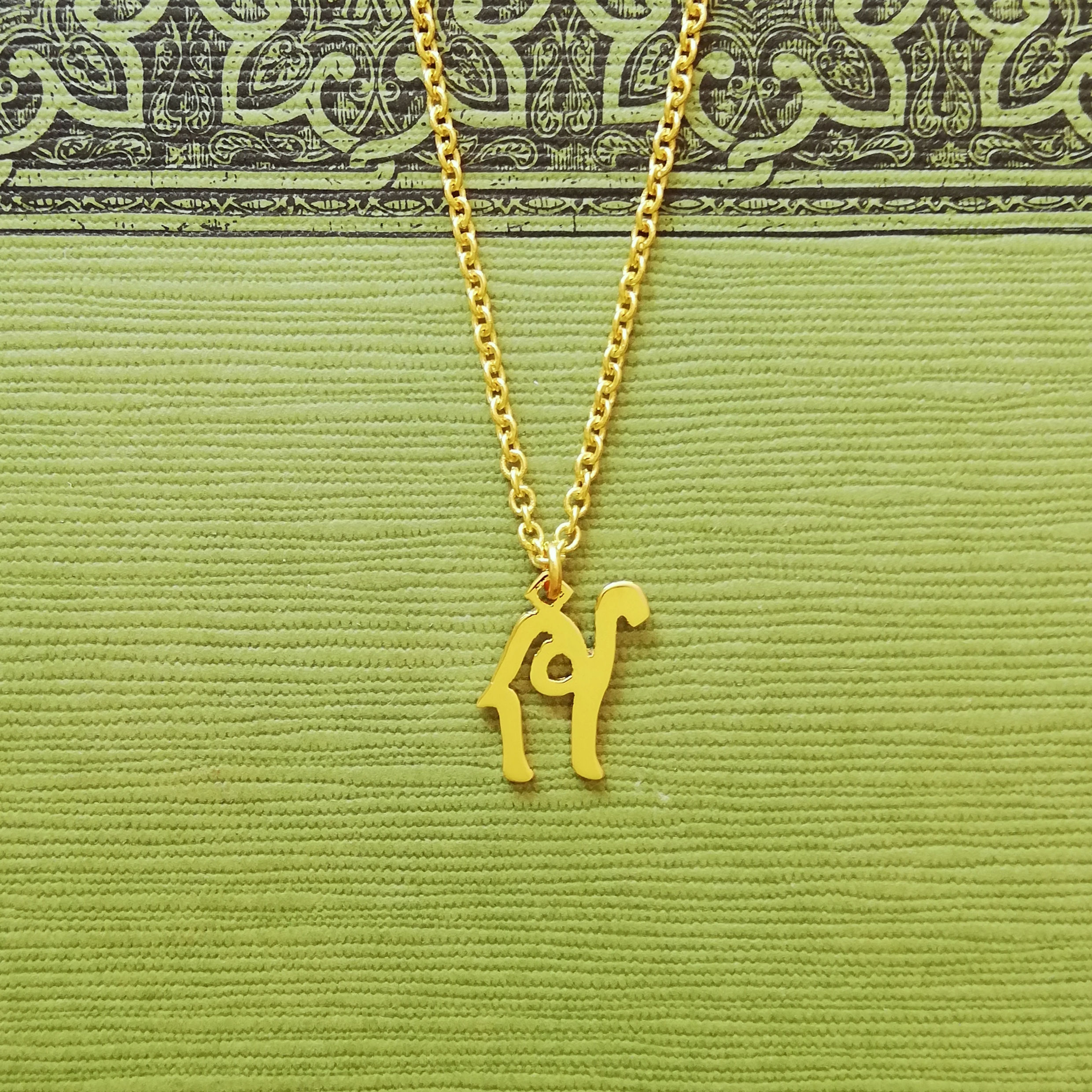 Gold camel necklace. The pendant top is sideway, facing right, designed with Arabic word.