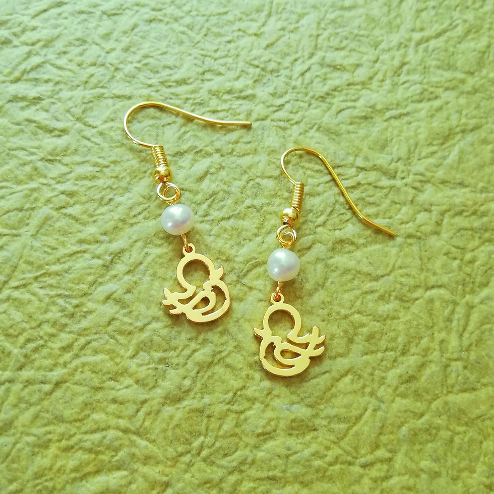 サムネイル： Gold chick silhouette and pearl earrings laying on green Japanese paper.