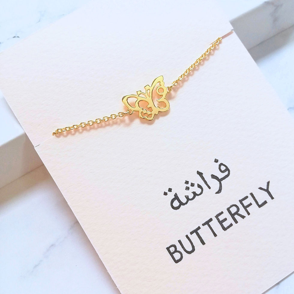 Thumbnail: Gold butterfly bracelet designed with Arabic word on a pale pink card.
