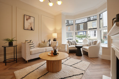 Staged lounge space with cream rug, furniture and bay window