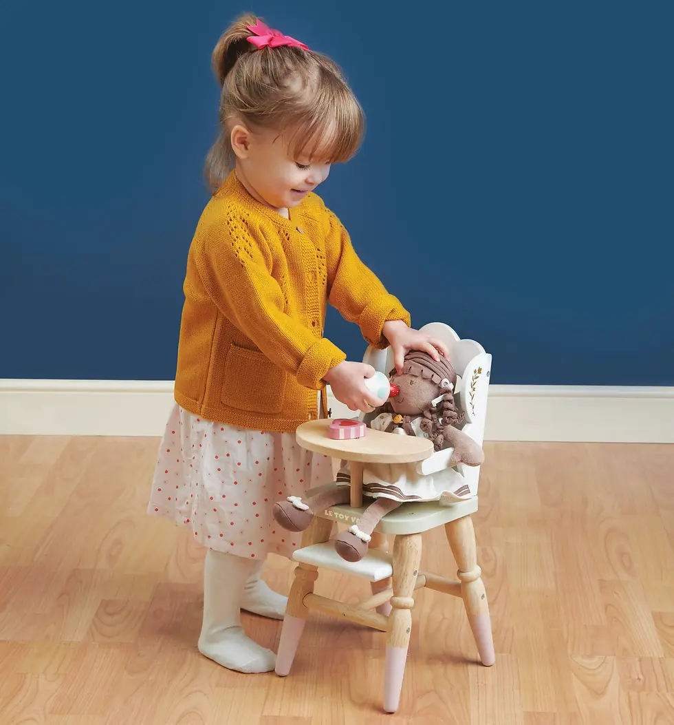 girl playing with wooden dolls high chair