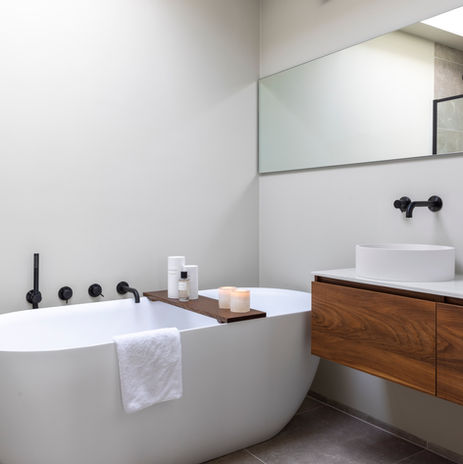 Badkamer in woonhuis Castricum met warm houten wastafelmeubel en ingetogen kleurenpalet.