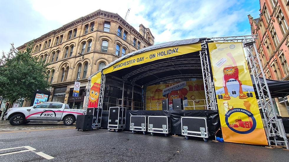 outdoor stage with banners Manchester day Deansgate