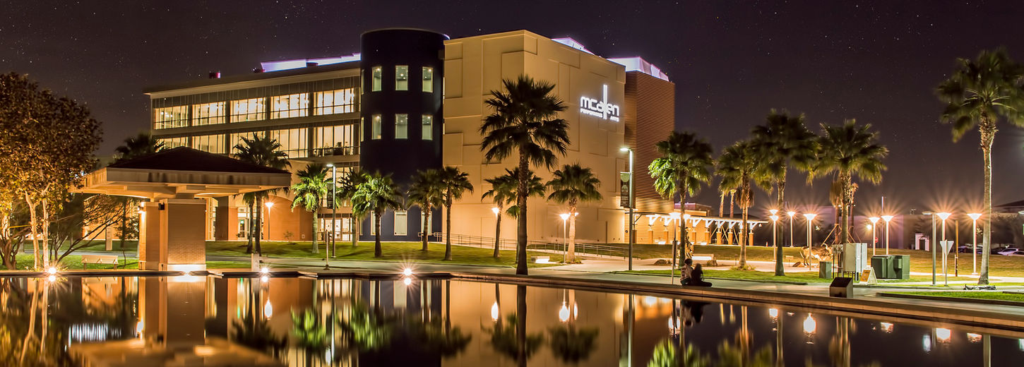 Nighttime shot of the City of McAllen's Performing Arts Center. It is a view from across the water of the McAllen Convention Center.