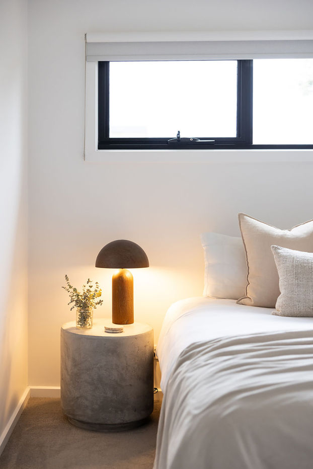 Bedroom styled with white linen and neutral accent colours. Warm and inviting space.