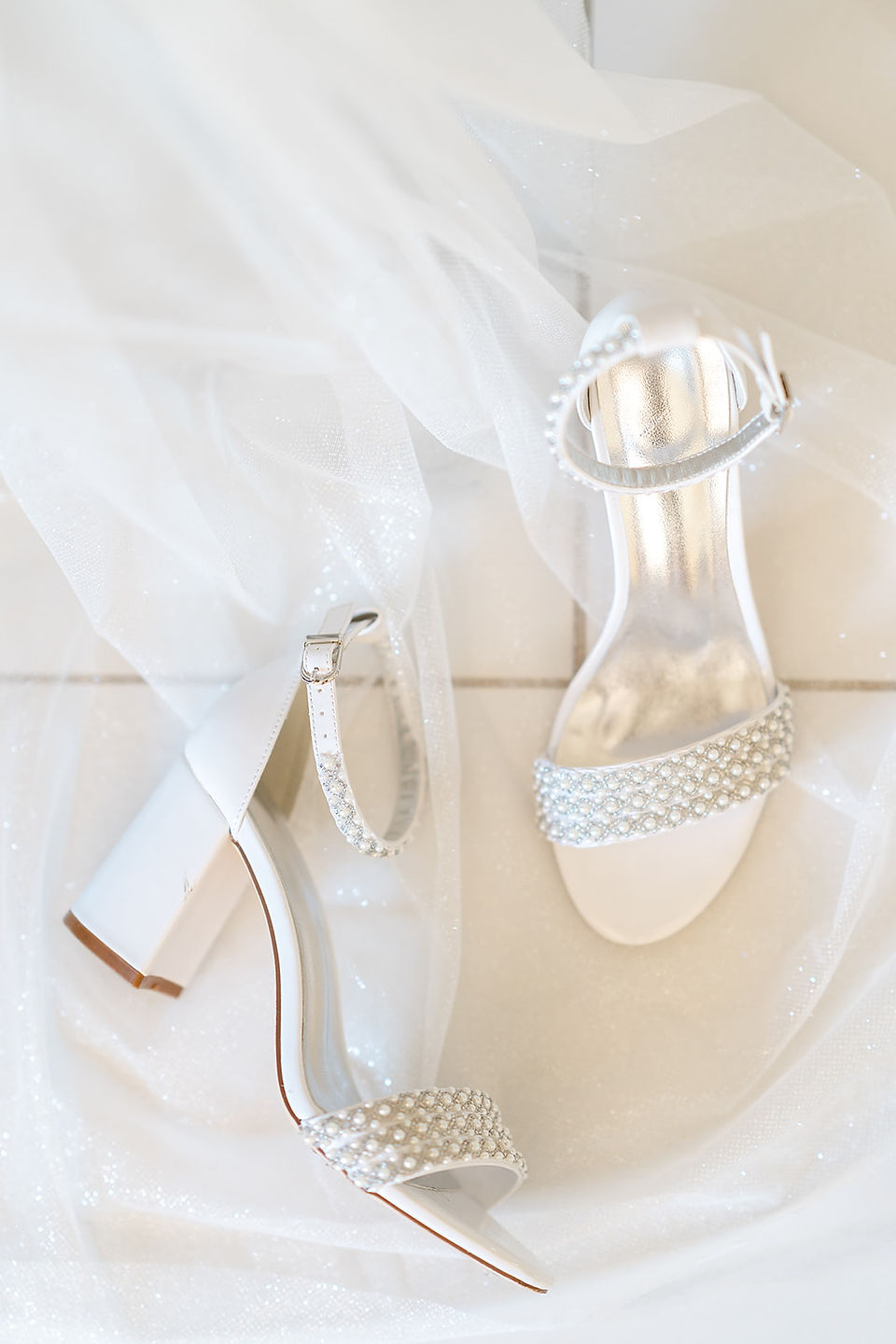 Elegant white bridal heels with pearl details and a flowing veil for a Zion National Park wedding.