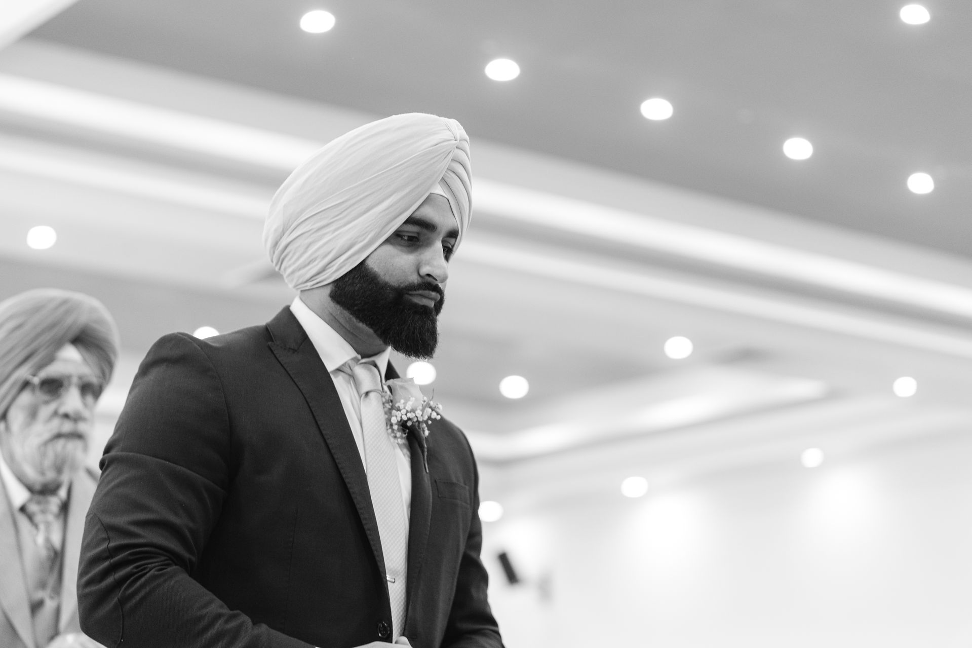 A cinematic black and white portrait of a Sikh groom wearing a traditional turban and sherwani, capturing the elegant legacy of a Sacramento South Asian wedding.