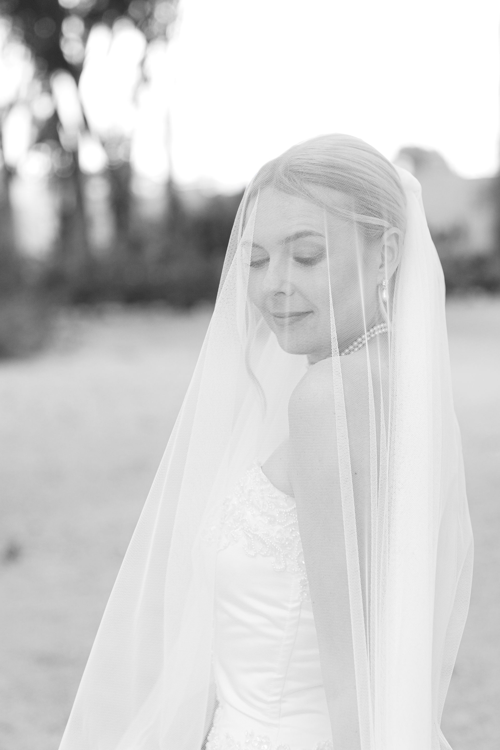 A beautiful solo portrait of the bride looking down, softly framed by her long white wedding veil during her Alicante destination wedding.