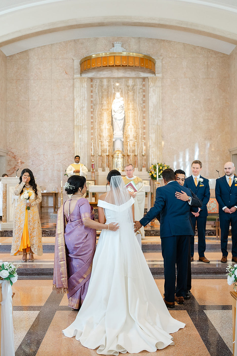 Sarah and Vince exchanging vows at the altar of Our Lady of the Pillar during their traditional Catholic ceremony in St. Louis.