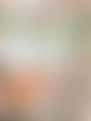 A couple in traditional attire sit among family at a floral-adorned ceremony. Pink roses and greenery create a vibrant, festive atmosphere.