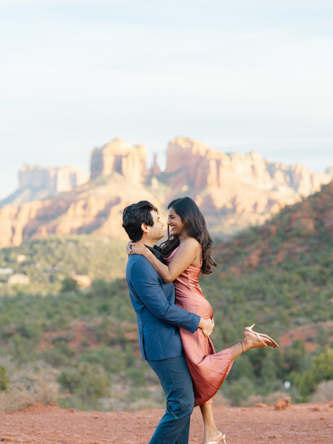 A romantic couple embracing under the ivy-draped stone arches of the historic Tlaquepaque Arts & Shopping Village in Sedona, Arizona.