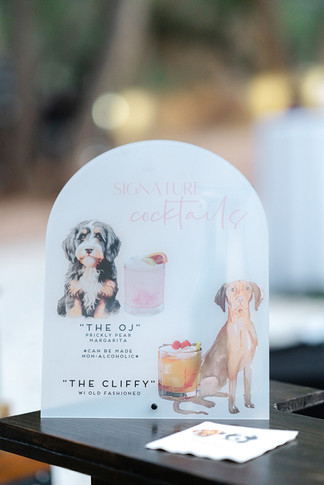 A custom signature cocktail menu featuring illustrated dogs at a Zion National Park wedding reception.