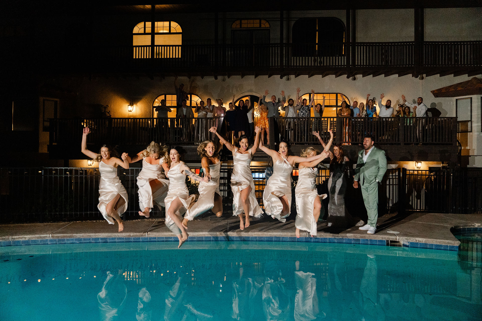 The bride, groom, and bridal party cheering by the pool during a fun and spontaneous night celebration at their Zion National Park Wedding.