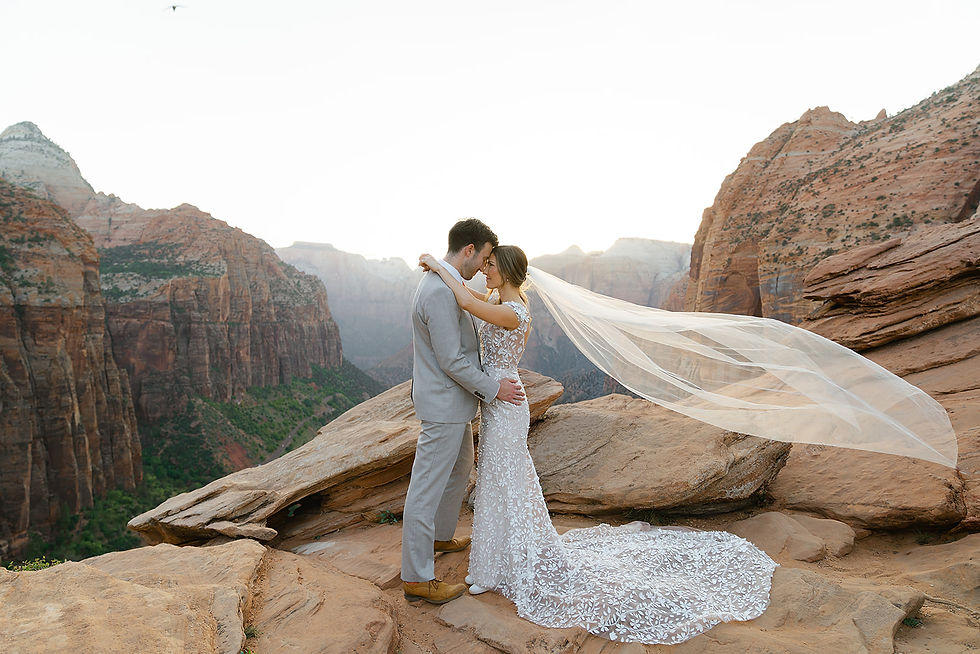 A bride and groom embracing on top of Canyon Overlook Trail