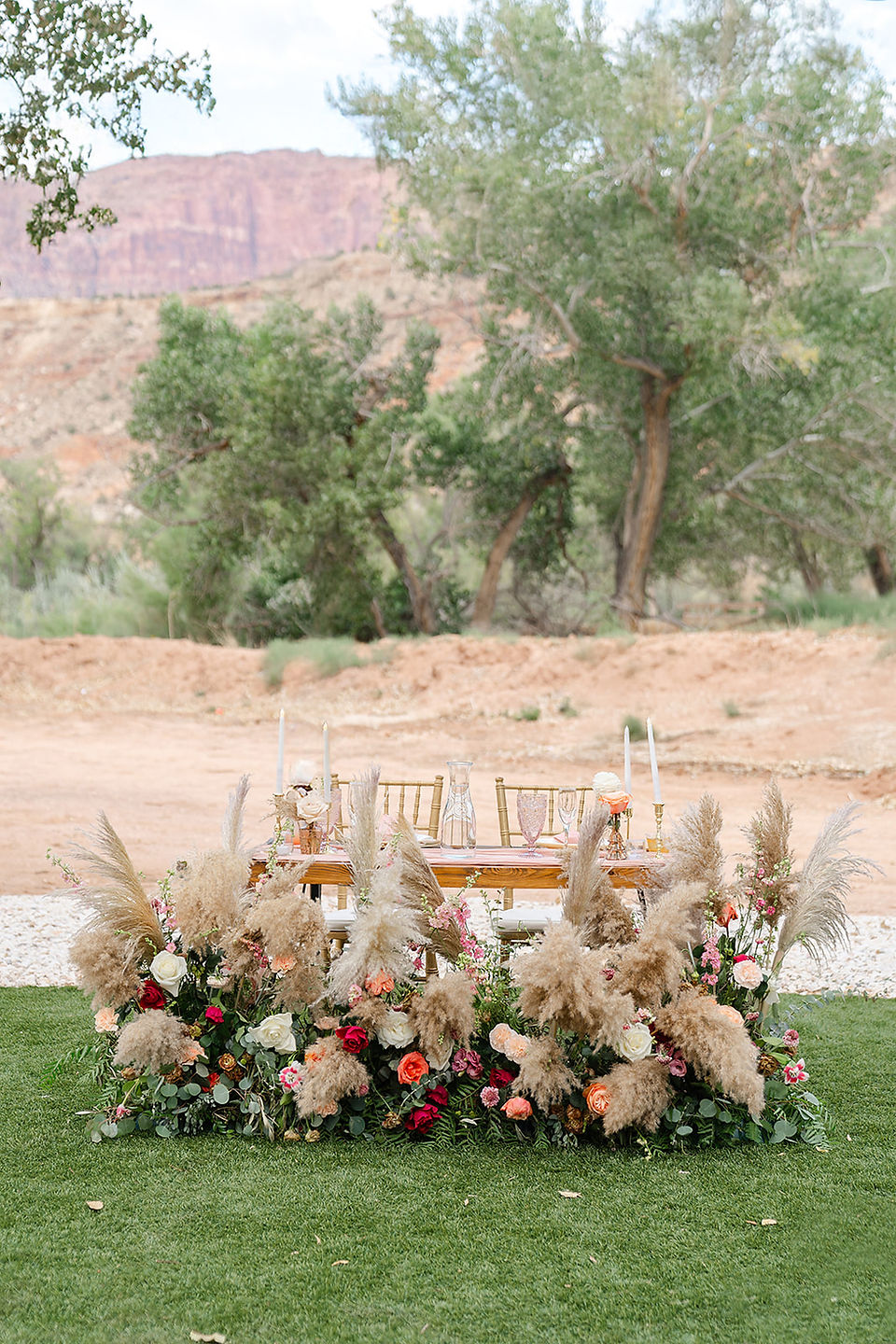 Outdoor wedding floral arrangement with pampas grass and white roses set against a desert backdrop for a Zion National Park wedding.