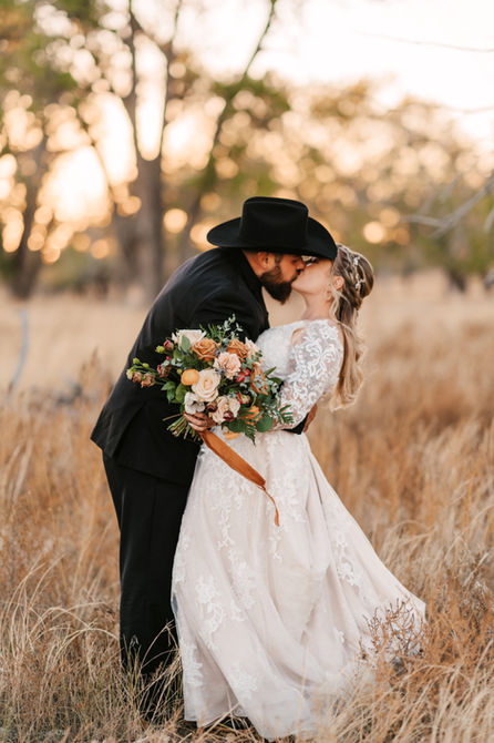 A romantic elopement portrait of a bride and groom embracing amidst the sprawling mountain landscape of Agate, Colorado.