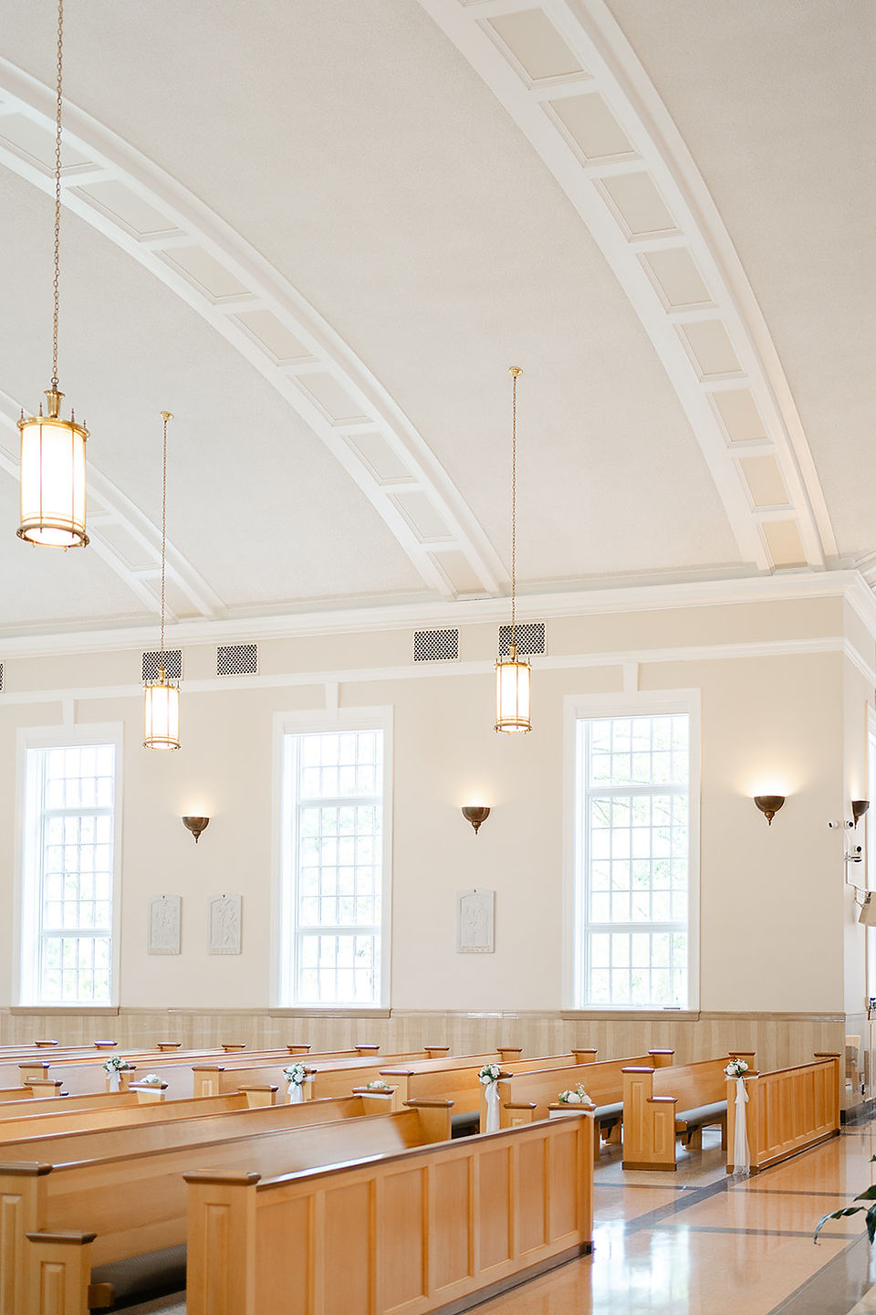 Elegant interior view of the wooden pews and bright windows at Our Lady of the Pillar during a Big Bow Events planned wedding in St. Louis.