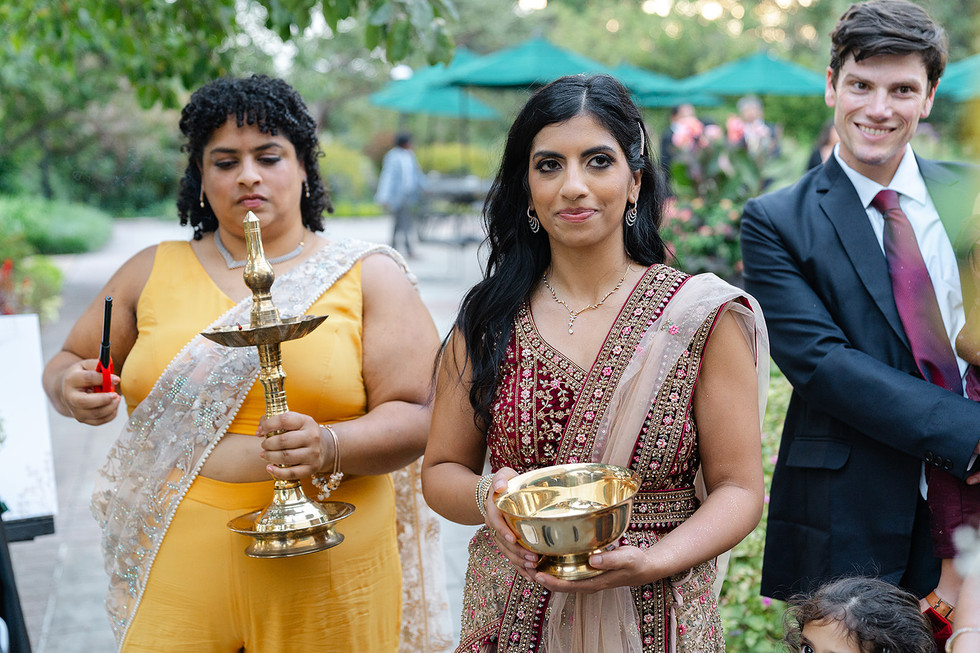 Vince's sisters participating in a ceremonial lighting of the Nilavilakku (traditional lamp) at the Norwood Hills Country Club reception in St. Louis, planned by Big Bow Events.