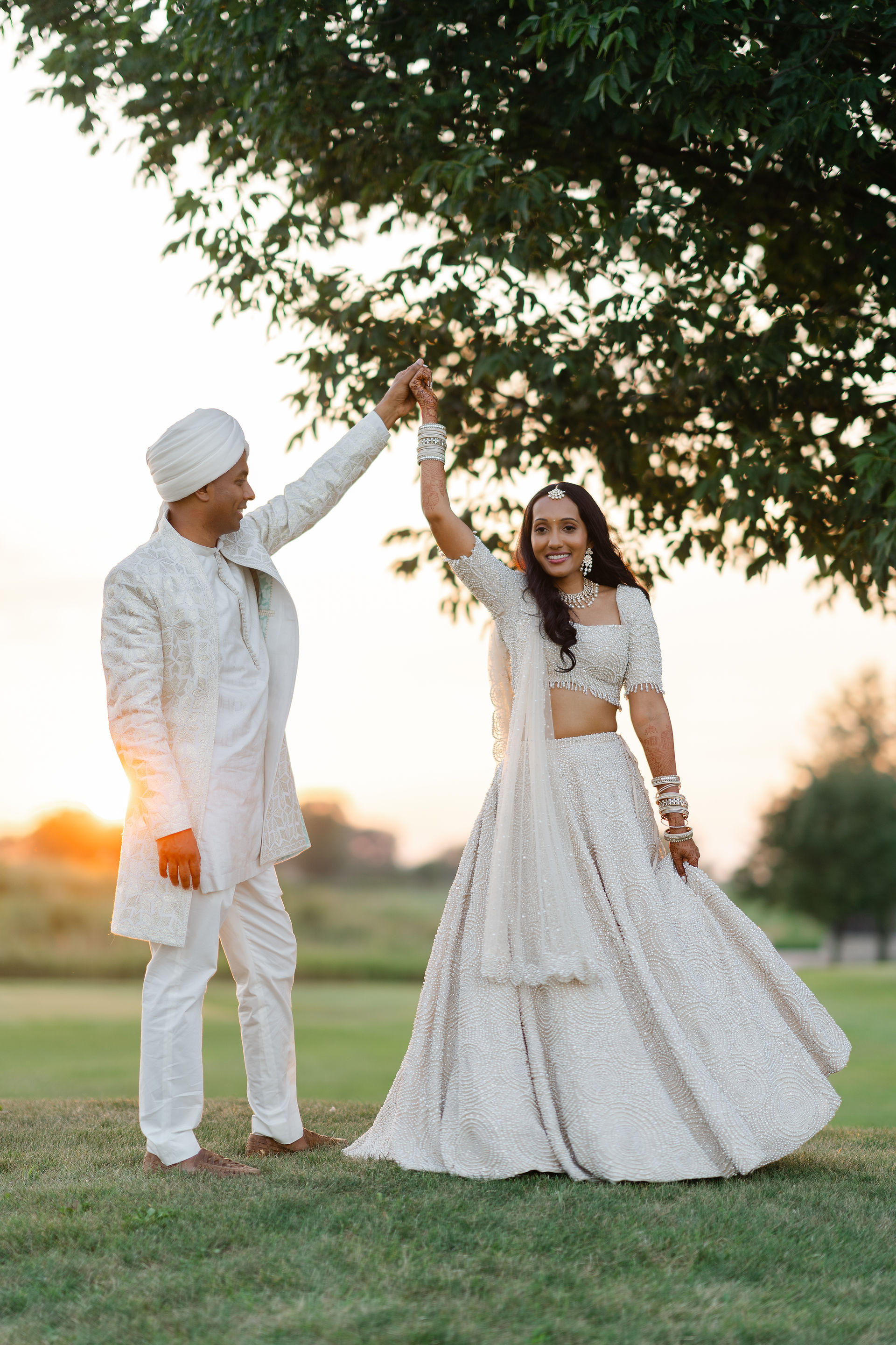 A romantic sunset portrait of Anvi and Denny dancing on the green at their Naperville wedding celebration.