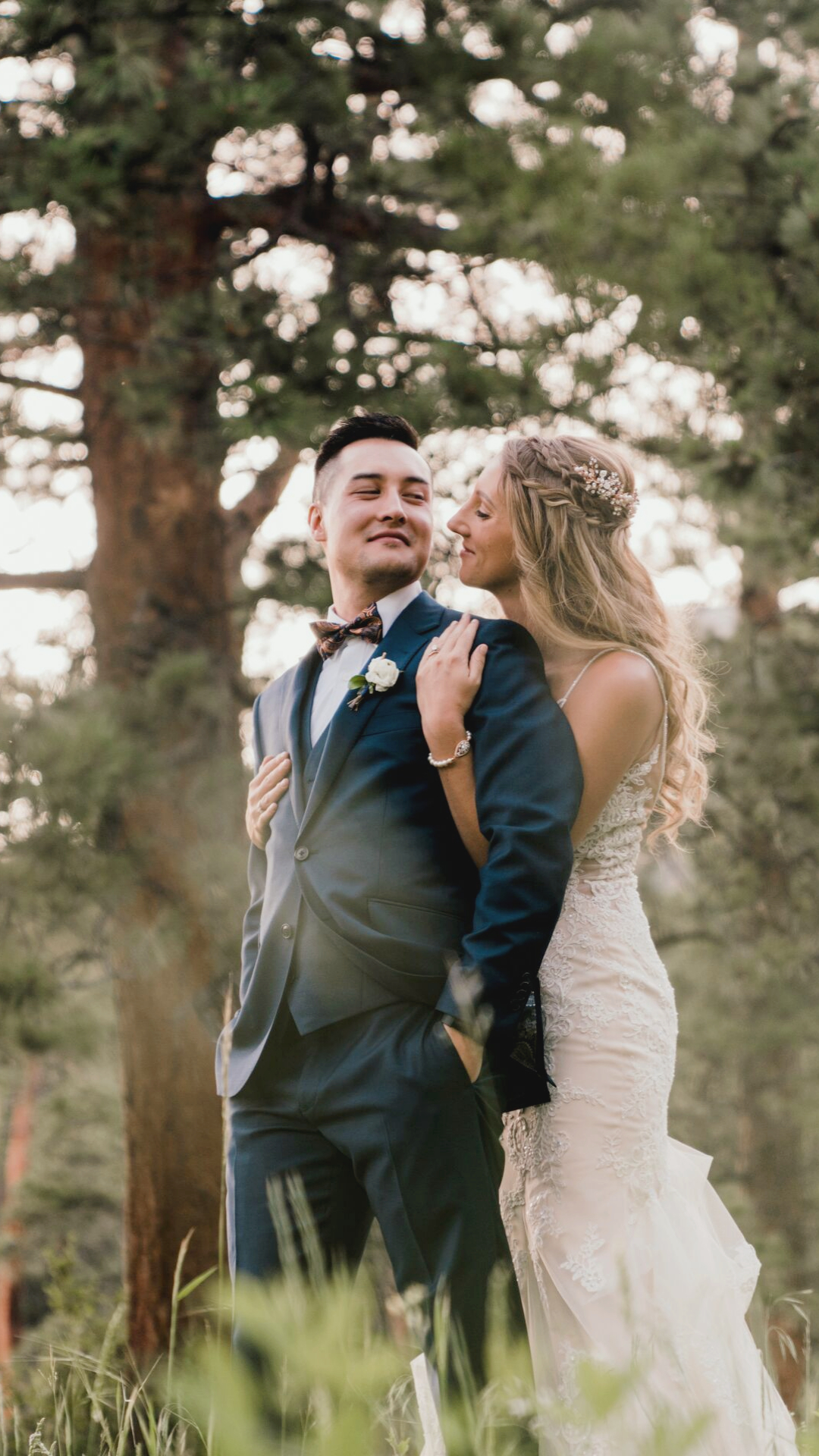 Intimate wedding portrait of a bride and groom embracing under a canopy of trees, with soft natural light filtering through the leaves at Della Terra Chateau.