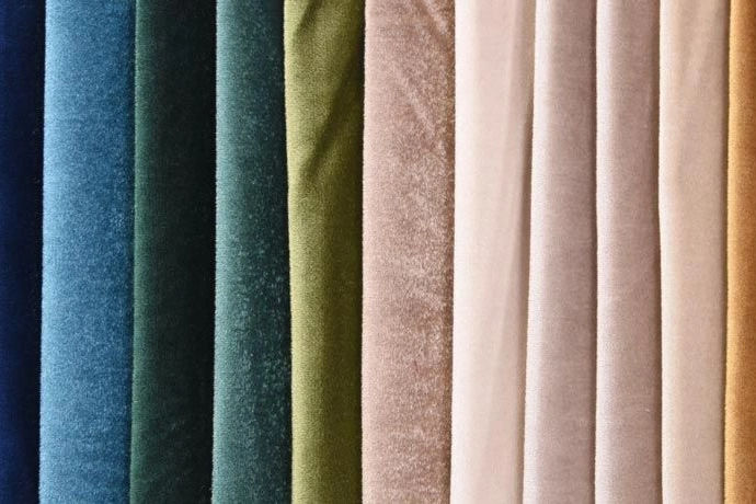 Tissus d’ameublement en velours, lin et coton dans des teintes naturelles – tendance déco intérieure 2025 axée sur les textures.