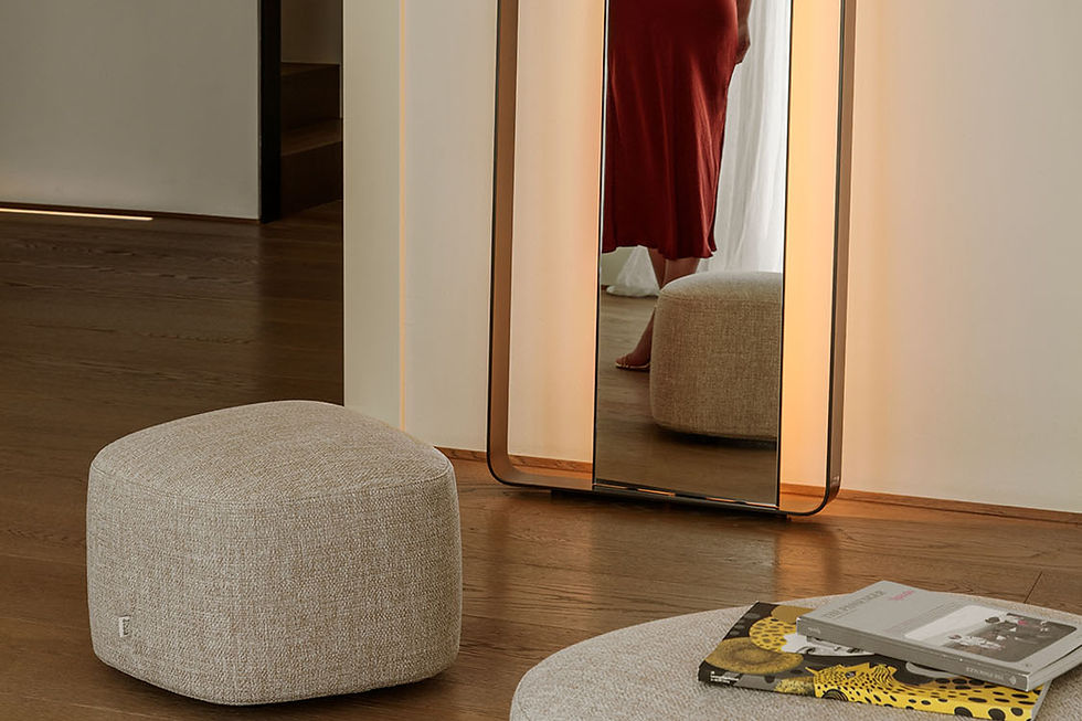 Pouf en tissu beige et miroir lumineux dans un intérieur minimaliste aux tons naturels et chaleureux