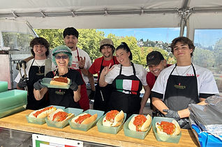 Serving and cook staff in front of food.