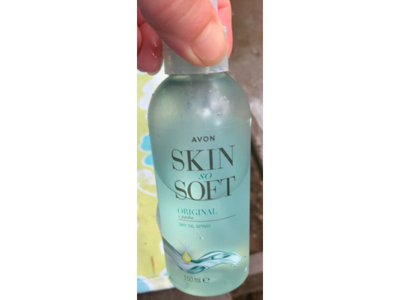 Close-up view of Avon Skin So Soft bottle with natural background
