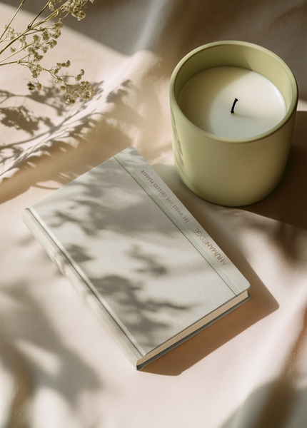 The Whole Life Success Planner sitting on a table next to a candle
