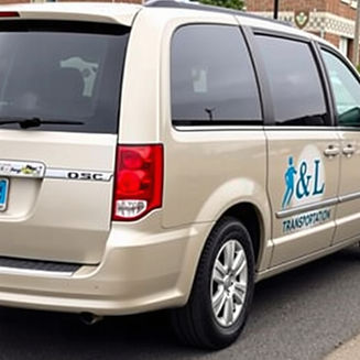 An image of a Dodge Town and Country van branded with A&L Transportation on the side, tran