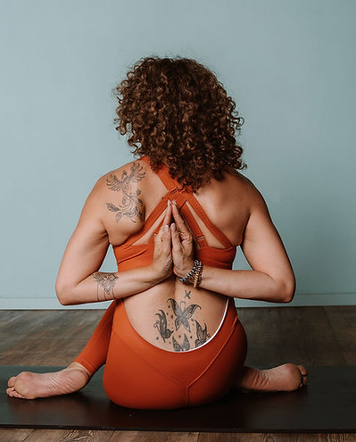 Vrouw in yogahouding, rug zichtbaar